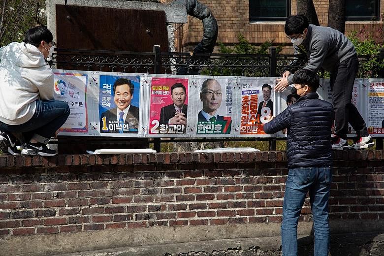 Officials of the National Election Commission putting up campaign posters in Seoul yesterday. South Koreans go to the polls on April 15 to elect a new National Assembly, the country's Parliament. PHOTO: EPA-EFE Independent candidate Lee Heng-suk, dre