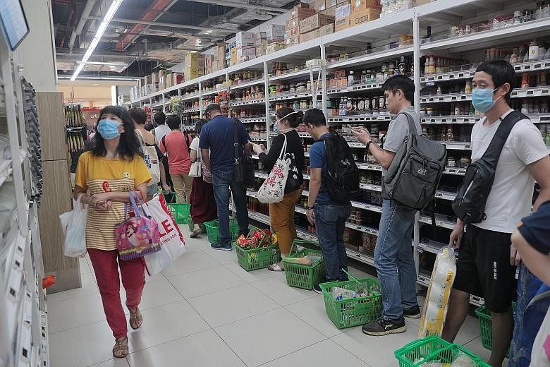 A queue of shoppers at FairPrice supermarket in Jem mall at about 6.20pm yesterday, after stricter measures were announced to curb the spread of the coronavirus. FairPrice said it is getting more manpower for crowd control and to help existing staff.