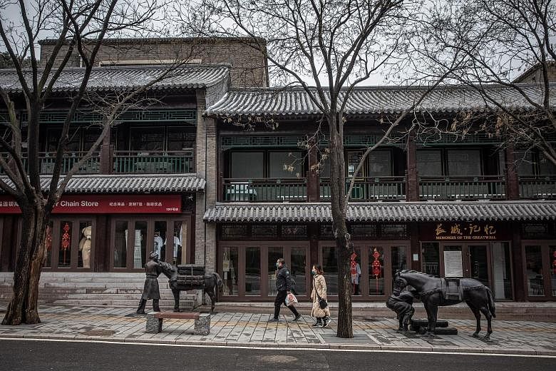 Tourists wearing protective face masks walk past closed restaurants and shops at the Badaling Great Wall area, in Beijing. The service sector is an important generator of jobs in China and accounts for about 60 per cent of its economy, which now look