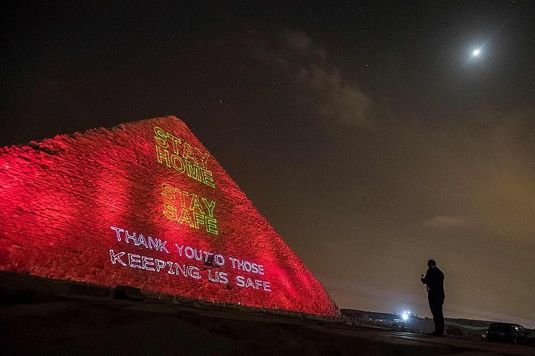 A laser projection on Egypt's Pyramid of Cheops bearing a stay-home message amid the pandemic, which has seen more than one million people worldwide infected with Covid-19. The International Monetary Fund has begun disbursing funds to requesting coun