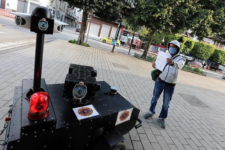 A Tunisian police robot known as PGuard checking the exit permit of a citizen while calling out to residents to respect a quarantine order in Tunisia's capital Tunis last Wednesday. Women queueing at a supermarket in Panama City, Panama, last Wednesd