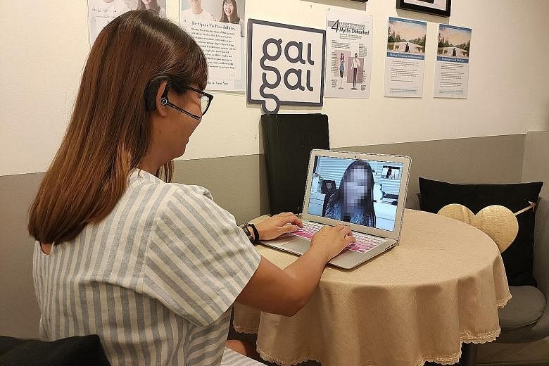 A relationship manager from dating agency GaiGai advising a client over a video call. Its members are offered the option of online dates.