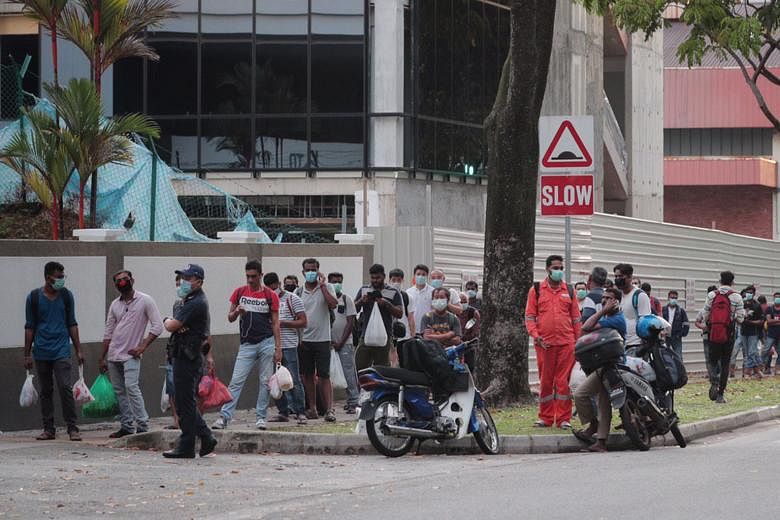 Above: Migrant workers returning yesterday to the Westlite Toh Guan dormitory. Some 6,800 of them have been told to stay in their rooms for 14 days. ST PHOTO: JASON QUAH Left: Workers at the S11 Dormitory @ Punggol yesterday. It has 63 virus cases. W