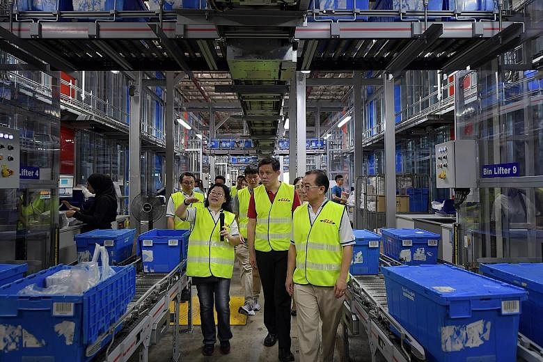 Trade and Industry Minister Chan Chun Sing (centre) taking a tour of FairPrice's Benoi Distribution Centre last month, accompanied by FairPrice chief executive Seah Kian Peng (right). Mr Seah yesterday said that prices will be kept affordable, despit