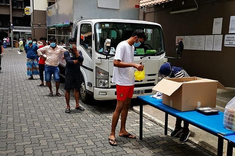 Far left: Workers queueing for food at Westlite Toh Guan dormitory yesterday. The dormitory was one of two gazetted as isolation areas on Sunday. Left: Cleaning being carried out at S11 Dormitory @ Punggol yesterday. The dormitory was also gazetted a