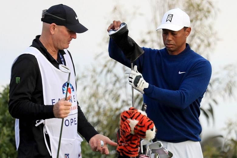 Tiger Woods and Joe LaCava, who carries the bag for the 15-time Major champion. Caddies are paid a weekly wage to cover expenses and may earn up to 10 per cent of a golfer's prize money. PHOTO: AGENCE FRANCE-PRESSE