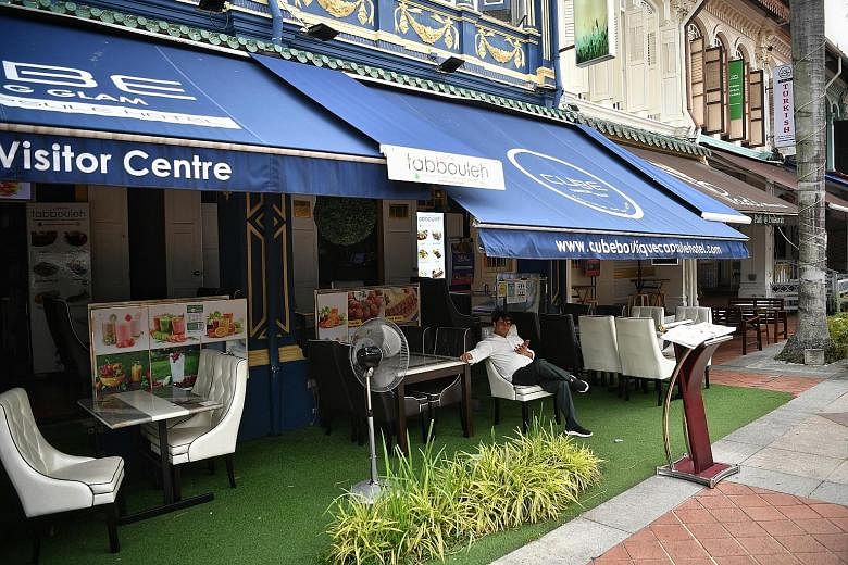 A staff member at a restaurant in Arab Street at around 5pm yesterday. ST PHOTO: ARIFFIN JAMAR Orchard Road was a ghost town when The Straits Times visited yesterday afternoon. ST PHOTO: GIN TAY A lone customer at Lau Pa Sat eatery at around 4pm yest
