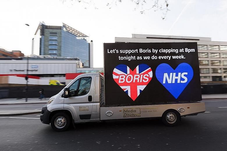 A vehicle with a billboard of support for British Prime Minister Boris Johnson driving past St Thomas' Hospital in London on Tuesday. Mr Johnson has been receiving standard treatment with oxygen and has not needed a ventilator for his Covid-19 condit