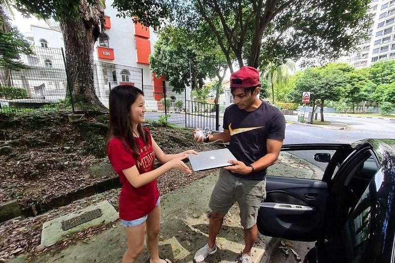 Former national sprinter U.K. Shyam receiving a laptop donated by National University of Singapore medical student Caitlin Wee Fern as part of an initiative to collect devices for less privileged students.