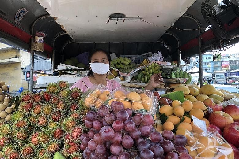 Above: Staff preparing food at Bangkok's Bharani restaurant, part of the Food for Fighters initiative that provides meals to medical staff at about a dozen hospitals. Left: Fruit seller Pitchanat Somanawat in her truck at Simummuang Market in Pathum 