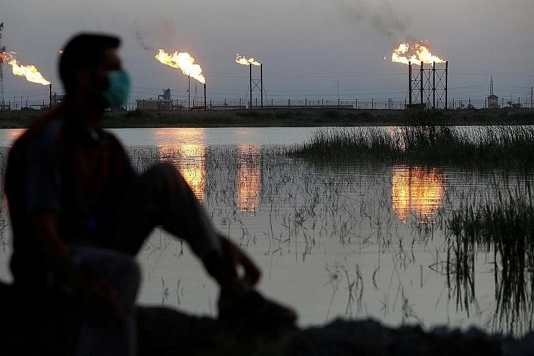 Flames from flare stacks at Nahr Bin Umar oil field, north of Basra, Iraq, on March 9. Oil prices have been wallowing near two-decade lows due to the coronavirus pandemic and a Saudi-Russian price war. PHOTO: REUTERS