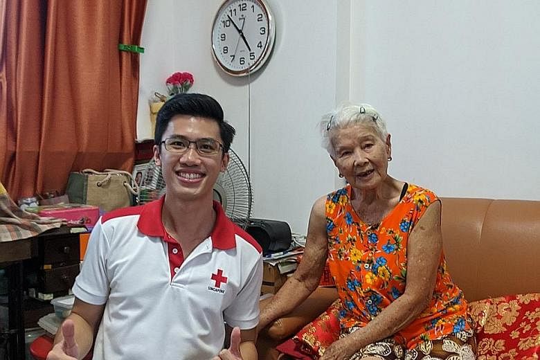 Above: A member of the Singapore Red Cross visiting Madam Nellie Woo, 83, at her flat last week. Below: Former sweeper Koh Ah Chew (right, on steps), 70, with a neighbour sitting 2m away from him at Chinatown Complex on Thursday. He said: "How is it 