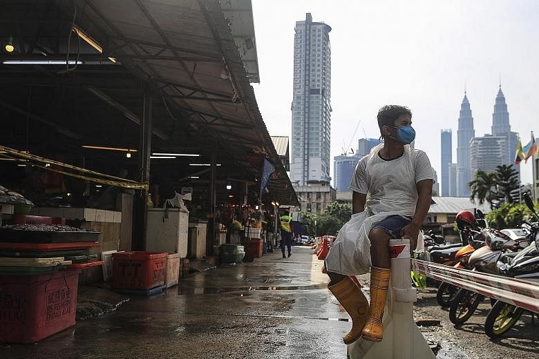 A vendor waiting for customers at a wet market in Kuala Lumpur yesterday. Malaysia entered its 24th day under the movement control order yesterday, which allows people to leave their homes only to buy groceries, medicine or food, or to carry out esse