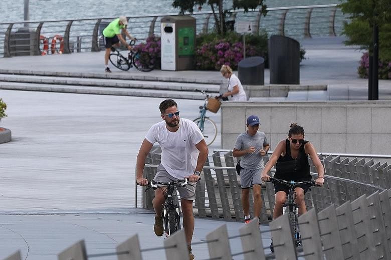 A jogger and cyclists on Jubilee Bridge on Wednesday. Researchers have found that those who walked or ran closely behind each other, and ended up in each other's slipstream, were at greatest risk of contamination. ST PHOTO: ONG WEE JIN