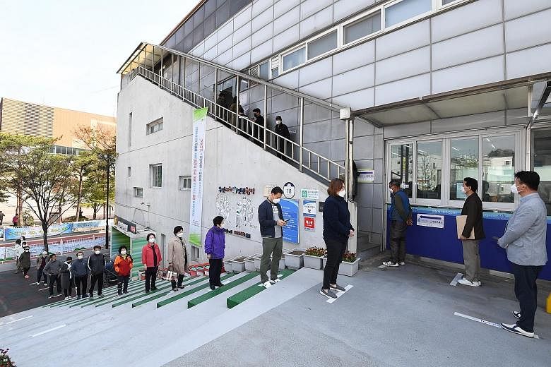 South Koreans waiting in line to cast their ballot while maintaining social distancing at a polling station in Seoul yesterday. South Korea is holding a two-day run of early voting in a bid to reduce crowds on election day next Wednesday. PHOTO: EPA-