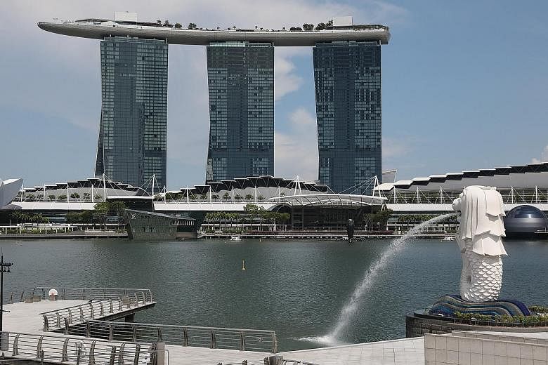 Tourists at the Merlion Park (left) in July last year, with Marina Bay Sands in the background, and what the area looked like on the second day of the circuit breaker in Singapore earlier this month. To contain the spread of the coronavirus, many cou