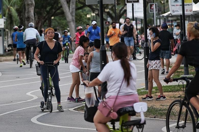 National Parks Board officers dispersing a group of people at Labrador Park at 6pm yesterday. Cyclists and joggers joined people out for a walk in East Coast Park yesterday. Even though most kept some form of social distancing, a number of them were 