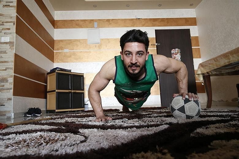 Ahmed Sawi, a Palestinian fitness and bodybuilding trainer, uses alternative tools during a training session at his home in Gaza City. PHOTO: AGENCE FRANCE-PRESSE