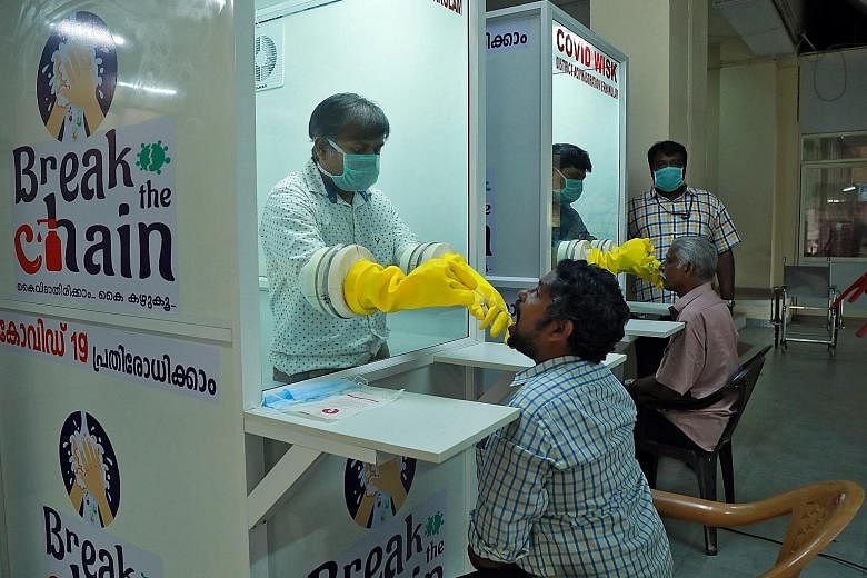 Staff from a medical college collecting swabs from people last week to test for the coronavirus at a walk-in sample kiosk in India's southern state of Kerala. Healthcare workers, who are on the front lines of the fight against Covid-19, increasingly 