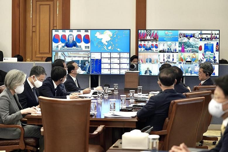 South Korean senior officials, including Foreign Minister Kang Kyung-wha (left), watching the teleconference of the summit at the presidential office Cheong Wa Dae in Seoul yesterday. Prime Minister Lee Hsien Loong attending the virtual summit to dis