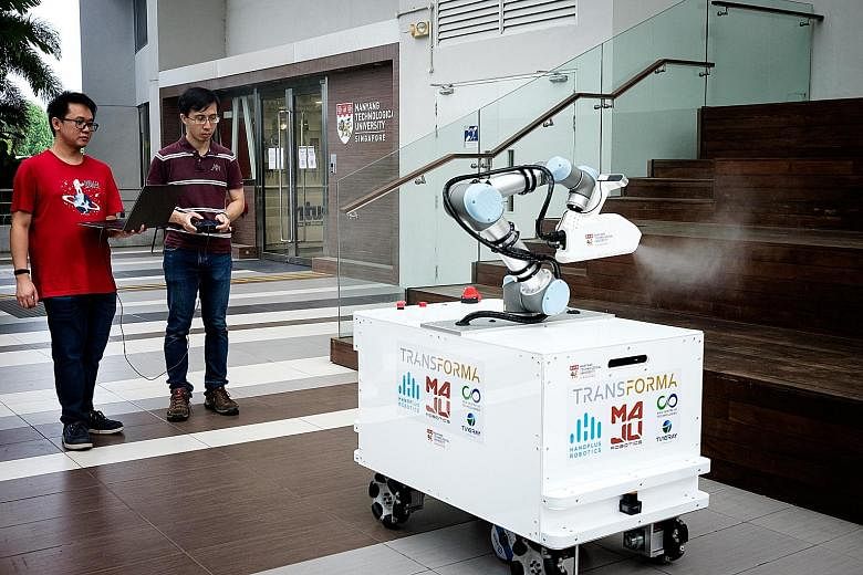 Mr Chong Zheng Hao (left) and Dr Quek Zhan Fan with the eXtreme Disinfection roBot, or XDBot. They are part of the Nanyang Technological University team that designed and built the robot in six weeks. The machine can disinfect large surfaces quickly,