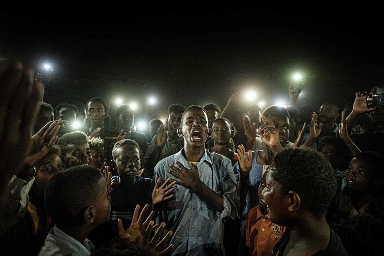 This photo of a cellphone-lit Sudanese demonstrator reciting protest poetry has won Japanese photojournalist Yasuyoshi Chiba a prestigious award.