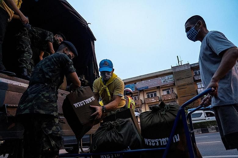 Soldiers and volunteers unloading provisions this week from Thailand's King Maha Vajiralongkorn and Queen Suthida for distribution to people amid the coronavirus pandemic.