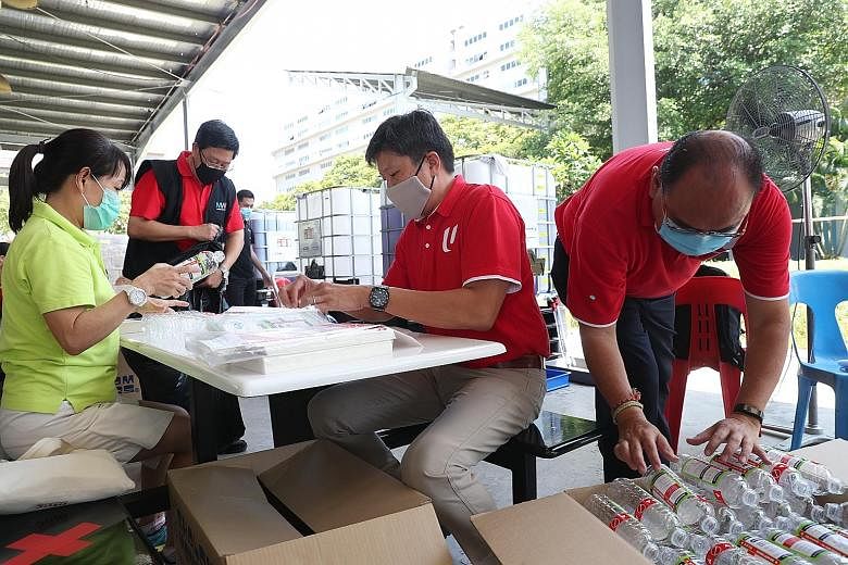 NTUC secretary-general Ng Chee Meng helping to prepare care packs for migrant workers in factory-converted dormitories yesterday.