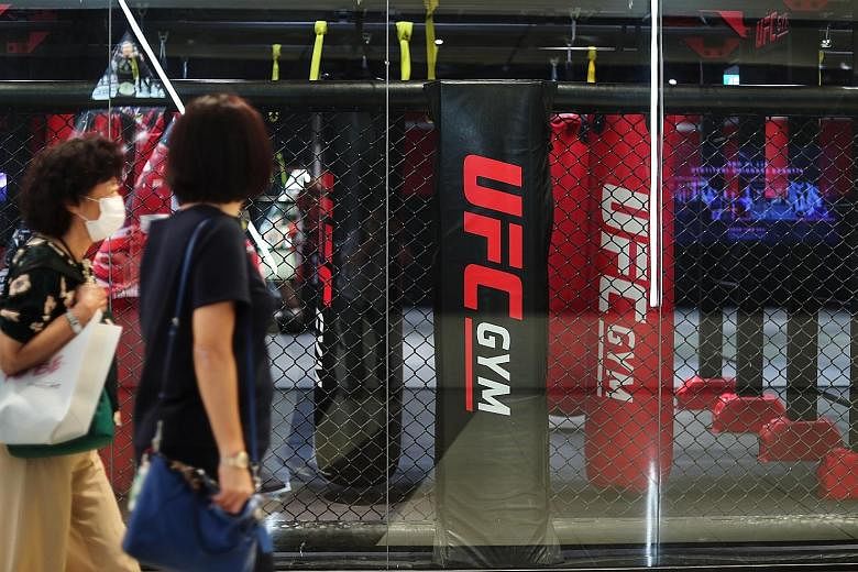 Masked women walking past the UFC Gym at CityLink Mall. Gym operators and other business owners in the sports fraternity have been adversely affected by the circuit breaker measures here. Minister Grace Fu (above) encouraged them, during a Facebook l