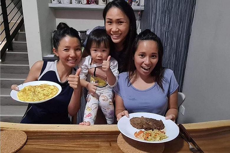 Fund manager Henrietta Yap, holding her daughter Beth, with her domestic helpers Kay Thi Khaing (left) and Alena Pacardo Palencia (right). With the circuit breaker in place, Ms Yap makes an effort to pitch in more at home. On Friday, she let her help