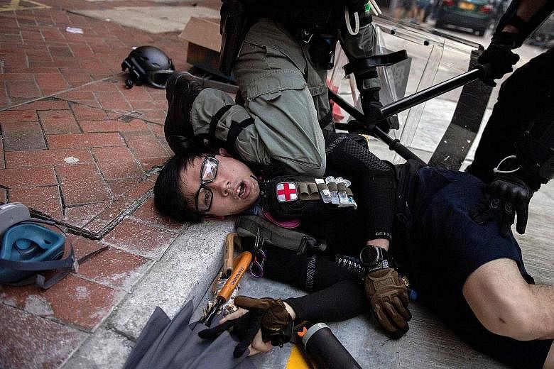 A photo taken on Oct 1 last year shows the Hong Kong police detaining a protester during demonstrations in Wanchai district as the city observed the National Day holiday to mark the 70th anniversary of communist China's founding. PHOTO: AGENCE FRANCE