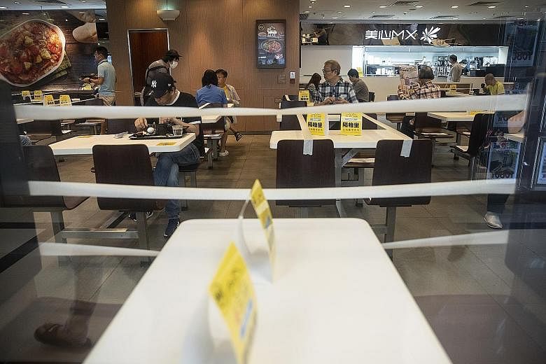 Tables and chairs taped off to enforce social distancing measures at a restaurant in Hong Kong. The city has extended its curbs for another 14 days even as it sees a fall in daily new Covid-19 infections. The Food and Health Bureau is to suspend the 