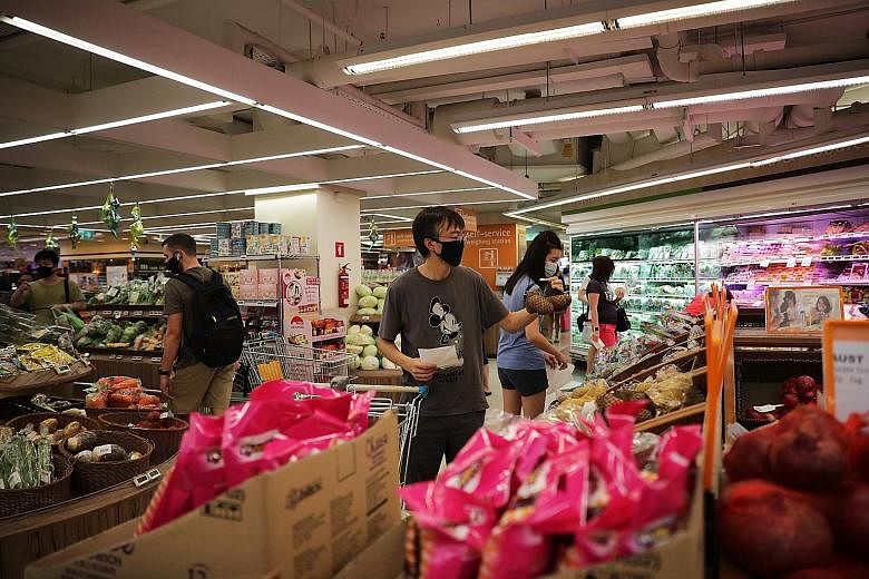 Shoppers at the FairPrice Finest supermarket in Bishan Junction 8 yesterday. One expert notes that a one-week moving average "is a general indicator of where trends are going" while another says that "moving average figures help everyone contextualis