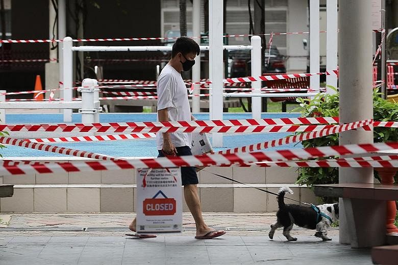 A man walking his dog in Jalan Sultan yesterday. Evidence suggests that workers providing essential services are getting infected.