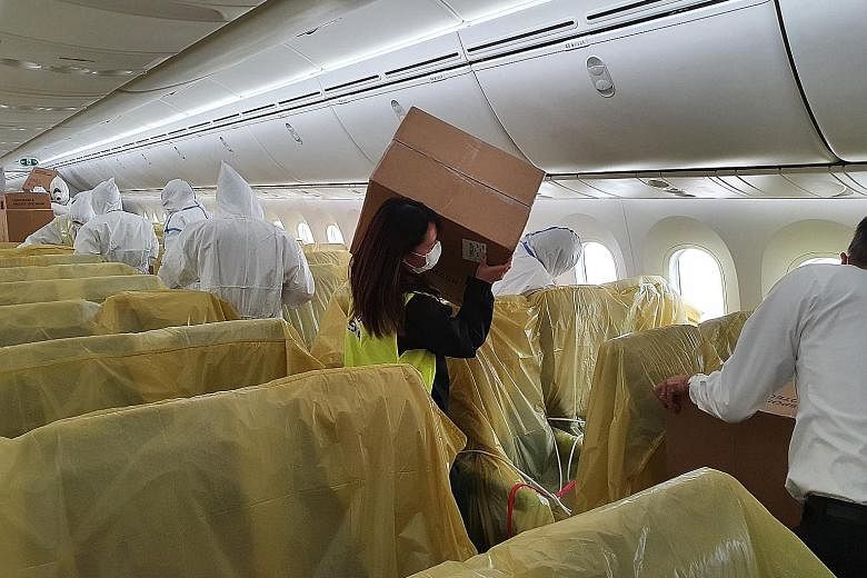 An SIA staff member with a box of medical supplies on board one of the carrier's passenger planes.