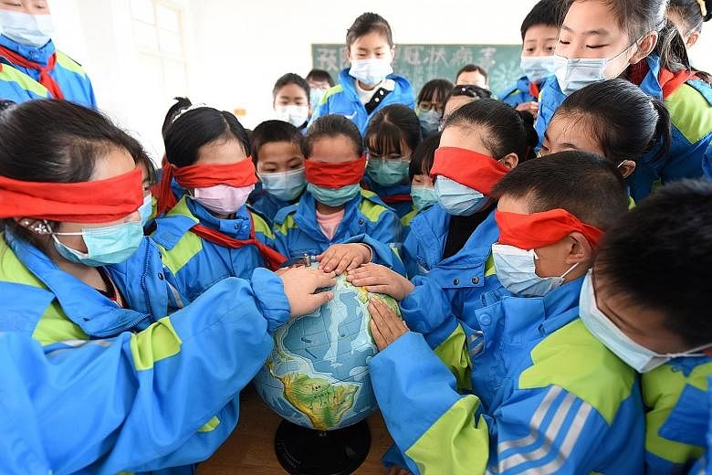 Pupils in Lianyungang city, China's Jiangsu province, touching a globe with their eyes covered as part of an Earth Day programme earlier this week. Worldwide lockdowns in response to the coronavirus pandemic have caused pollution levels to plunge and