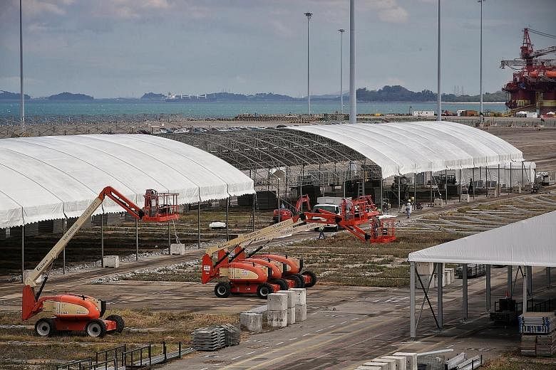 Marquees being set up (left) near rows of cars (above) at the Tanjong Pagar Terminal site on Wednesday. Trucks carrying building materials could also be seen entering the terminal, which has been vacant since port operations were relocated to Pasir P