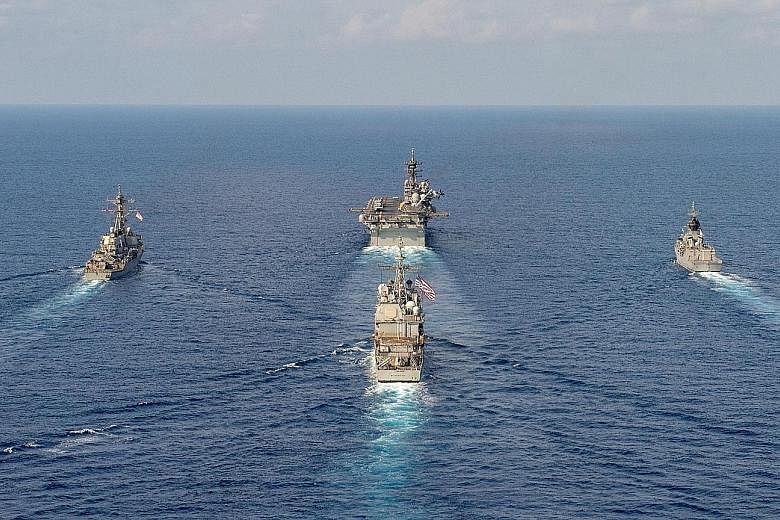 The Parramatta (top right) conducting manoeuvres in the South China Sea with the USS America (top centre), the USS Barry (top left) and the USS Bunker Hill, in this April 18 handout photo from the Australian Department of Defence. Commander Anita Nem