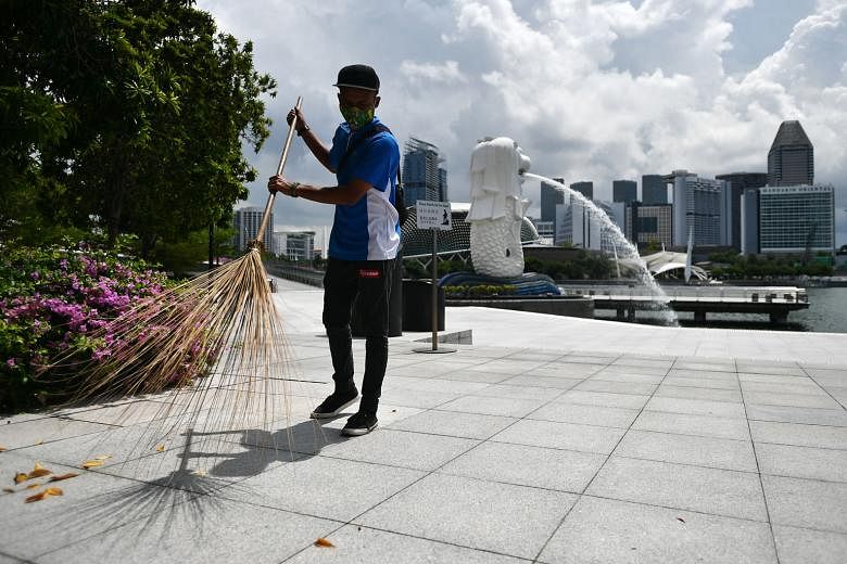 Cleaner Hamedi Hamzan at work at the deserted Merlion Park on Thursday. Visitor arrivals fell by half in February compared with the year before, and the numbers for last month are expected to hit new lows.