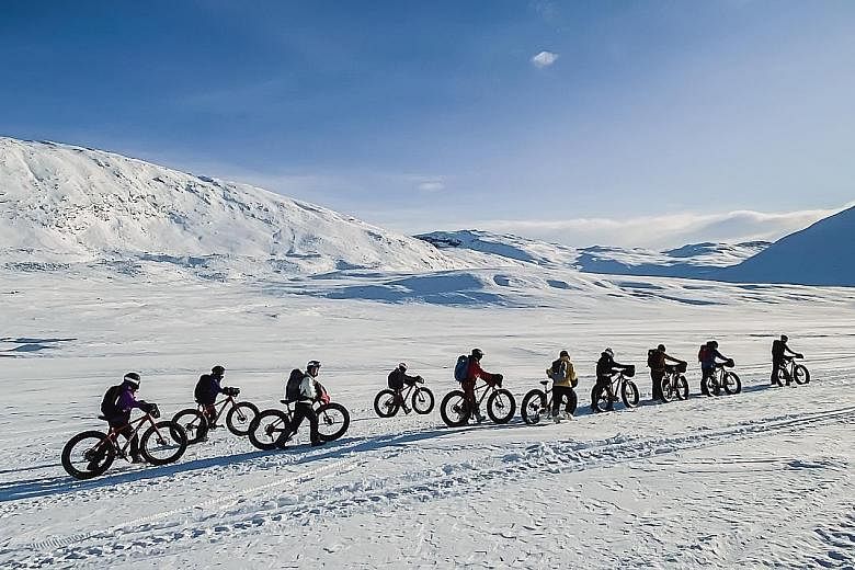 With soft snow on the trail, team members get off their fat bikes to push them instead.