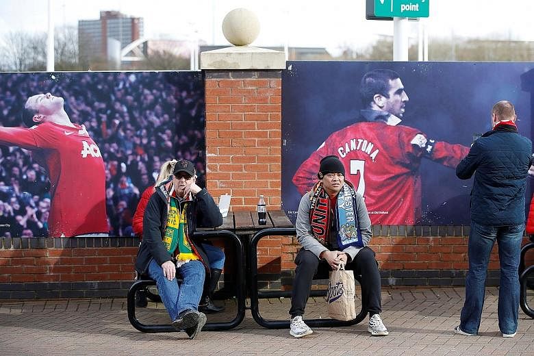 Fans outside Old Trafford before the Manchester United v Manchester City match on March 8. A restarted season behind closed doors will come at a cost to clubs. PHOTO: REUTERS