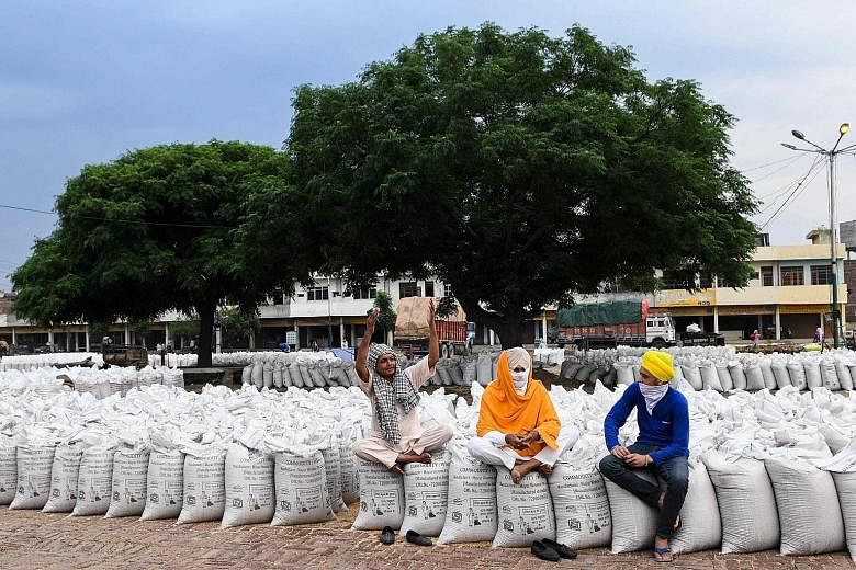 Farmers at a grain market in Amritsar yesterday. Consumption in India is down, with salary cuts and layoffs starting in some sectors.