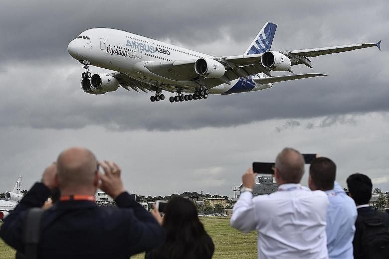 Plane enthusiasts watching an Airbus A-380 during a flight demonstration at the Farnborough International Air show in Britain, in this 2016 photo. The company is "bleeding cash at an unprecedented speed", Airbus chief Guillaume Faury told staff in a 