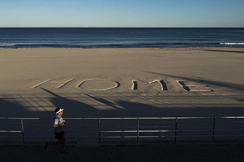 A message written in the sand on Australia's Bondi Beach urging people to stay home. Canberra last week said it would push for an international probe into the coronavirus pandemic at the World Health Assembly next month. Commuters, all with face mask