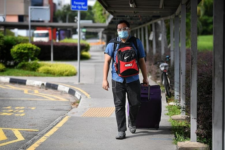 Malaysian Muhammad Bari Arshad, 28, a management trainee, leaving Singapore yesterday morning to return to Malaysia, as new rules for returning Malaysians kicked in.