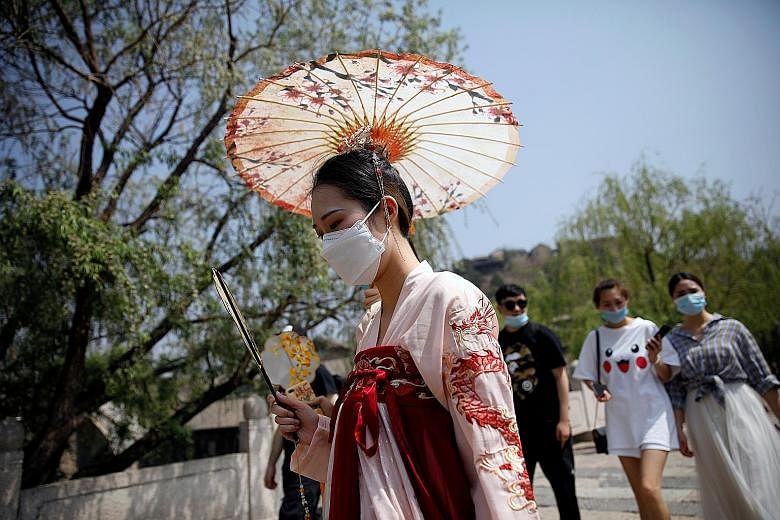 A visitor to Gubei Water Town yesterday wearing a face mask and traditional Chinese clothing. The town, 110km from Beijing, normally teems with tourists on Labour Day, but crowds were thin yesterday. PHOTO: REUTERS