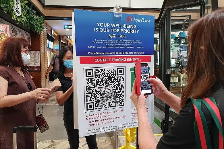 Customers scanning the SafeEntry QR code at Northpoint City's FairPrice outlet on Thursday. SafeEntry is now being used by essential sector businesses such as supermarkets, clinics and F&B outlets at over 2,100 locations. ST PHOTO: ONG WEE JIN
