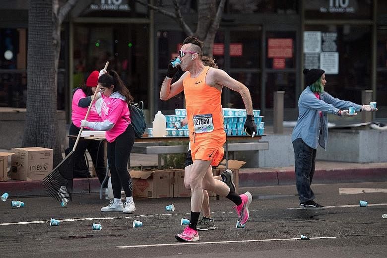 Runners drinking water provided by volunteers as they competed in the Los Angeles Marathon on March 8.