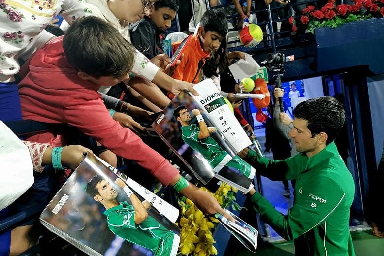 World No. 1 Novak Djokovic signing autographs for fans in Dubai in February. This is being discouraged under the new ITF guidelines, while players cannot even shake hands or shower after their matches.