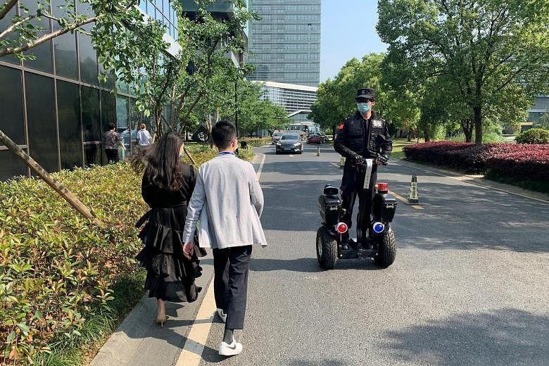 Equipped with an infrared sensor and a camera, the glasses measure temperatures on the move, allowing the wearer to "see" people's temperatures. A security guard wearing thermal glasses developed by Chinese start-up Rokid patrolling on a scooter, ami